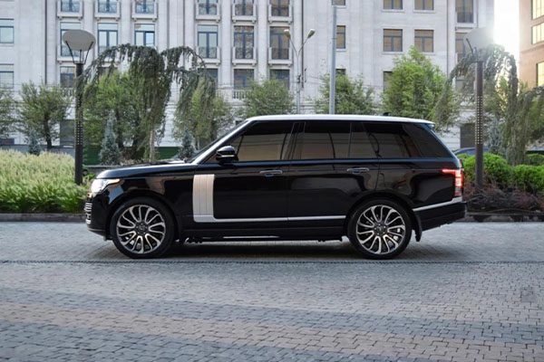Side profile of a sleek Range Rover, showcasing its elegant design and commanding presence, ideal for business or leisure in London.